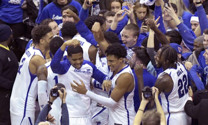 Seton Hall players celebrate with students after the team defeated Texas in an NCAA college basketball game, in Newark, N.J., on Dec. 9, 2021. (Bill Kostroun/AP Photo)