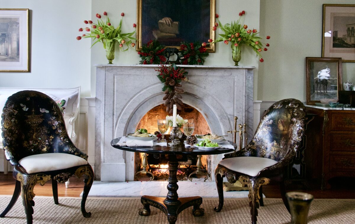 Sitting by the fireplace creates a cozy, relaxed moment to delight in the season. Any small, moveable table works well, dressed up with a nice tablecloth. (Victoria de la Maza)
