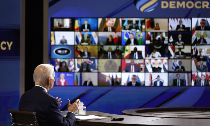 U.S. President Joe Biden looks at a video screen displaying the participants in the Summit for Democracy as he delivers opening remarks in the South Court Auditorium in Washington on Dec. 9, 2021. (Chip Somodevilla/Getty Images)