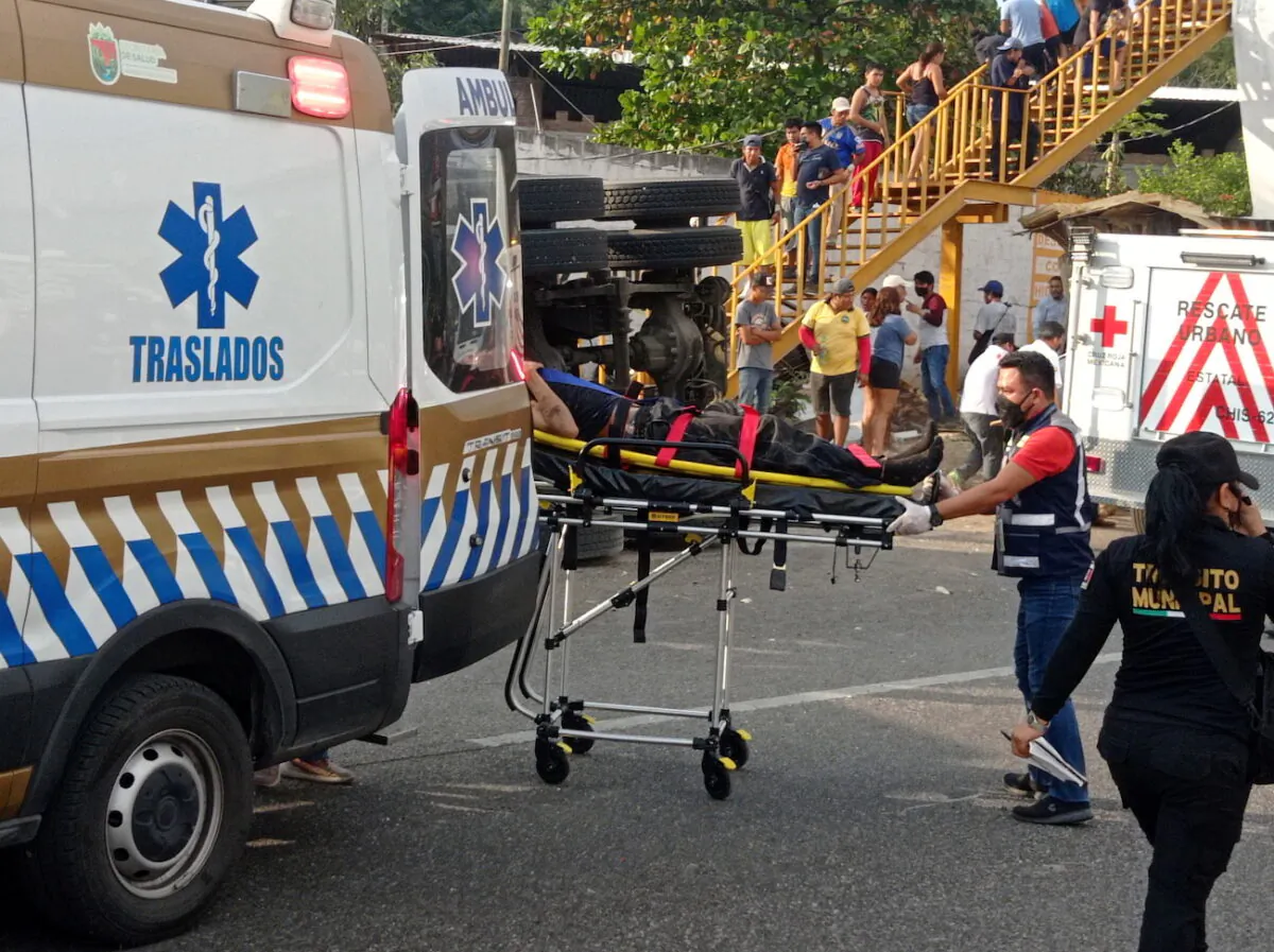 Emergency crew assist an injured person after a trailer crash in the southern Mexican state of Chiapas killed 55 people, most of them from Central America, officials said in Tuxtla Gutierrez, Chiapas, Mexico, on Dec. 9, 2021. (El La Mira/via Reuters)