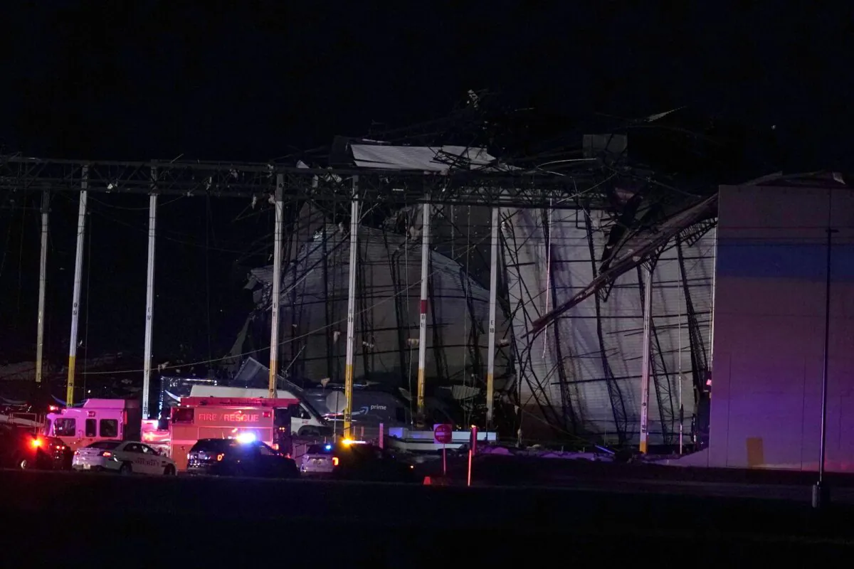 Emergency vehicles stage outside an Amazon fulfillment center after it was heavily damaged when a strong thunderstorm moved through the area in Edwardsville, Ill., on Dec. 10, 2021. (Jeff Roberson/AP Photo)
