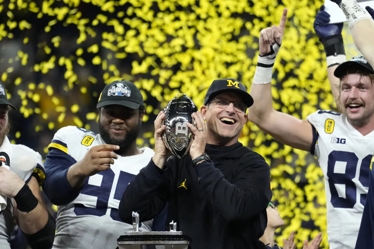 Michigan head coach Jim Harbaugh celebrates with his team after the Big Ten championship NCAA college football game against Iowa in Indianapolis, Dec. 4, 2021. (AJ Mast/AP Photo/)