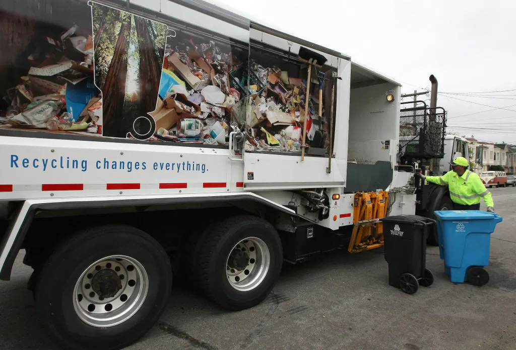 Norcal Waste worker Angelo Borg moves a bins with trash and recyclable  materials while collecting recyclable materials in a Sunset district neighborhood in San Francisco on June 11, 2009. (Justin Sullivan/Getty Images)