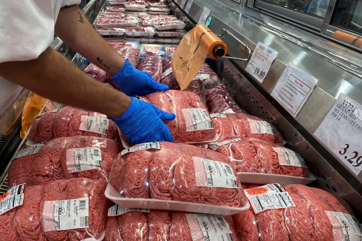 A worker stacks packets of ground beef in the meat section of a store in Webster, Texas, on May 5, 2020. (Adrees Latif/Reuters)