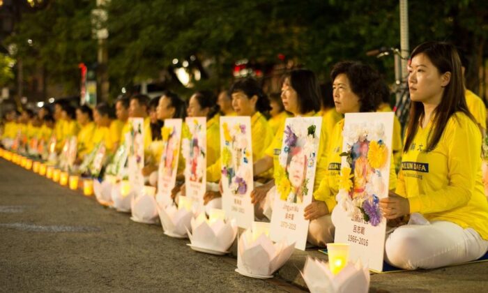 Falun Gong practitioners hold a candlelight vigil in front of the Chinese Consulate in Toronto on July 13, 2019, holding photos of fellow adherents who had died as a result of persecution in China. (Handout)