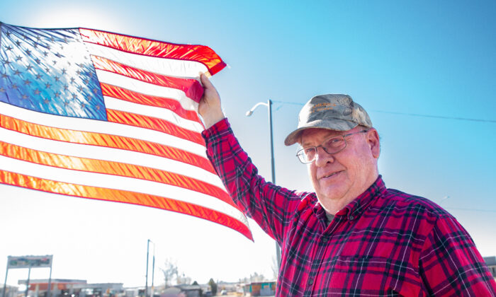 Resident Richard Frei holds an American Flag in Winslow, Ariz., on Dec. 4, 2021. (John Fredricks/The Epoch Times)