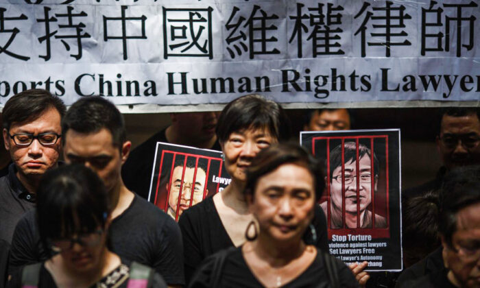 Portraits of detained Chinese human rights lawyers Jian Tianyong (L) and Wang Quanzhang are seen as Hong Kong pro-democracy activists observe a silent protest in support of human rights lawyers in China outside the Court of Final Appeal in Hong Kong's Central district on July 9, 2017.
(Tengku Bahar/AFP/Getty Images)