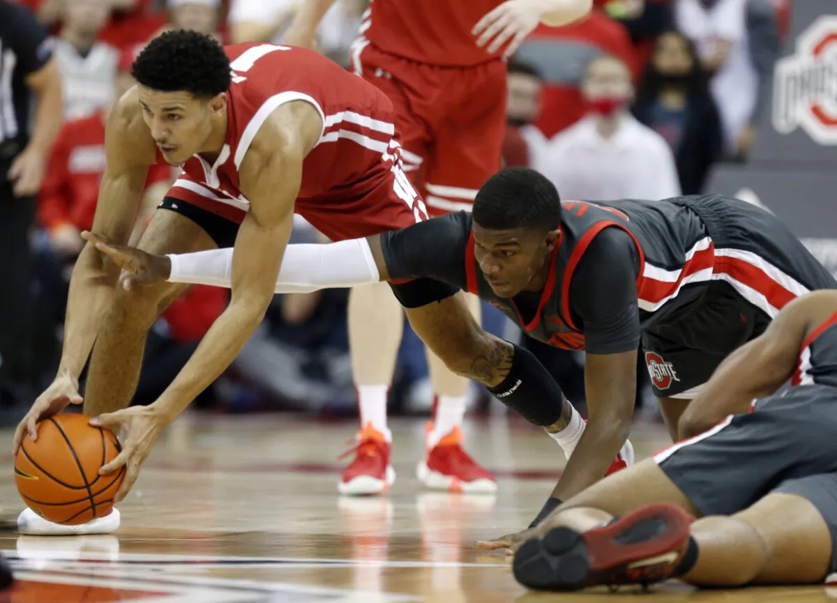 Wisconsin guard Jonathan Davis (L)  and Ohio State forward E.J. Liddell reach for a loose ball during the first half of an NCAA college basketball game in Columbus, Ohio, on Dec. 11, 2021. (Paul Vernon/AP Photo)