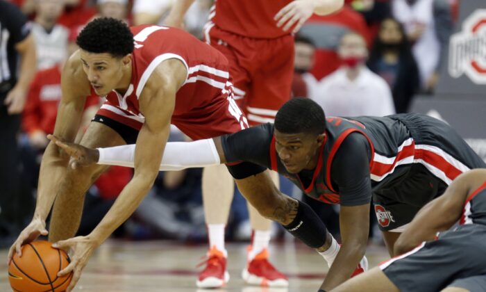 Wisconsin guard Jonathan Davis (L)  and Ohio State forward E.J. Liddell reach for a loose ball during the first half of an NCAA college basketball game in Columbus, Ohio, on Dec. 11, 2021. (Paul Vernon/AP Photo)