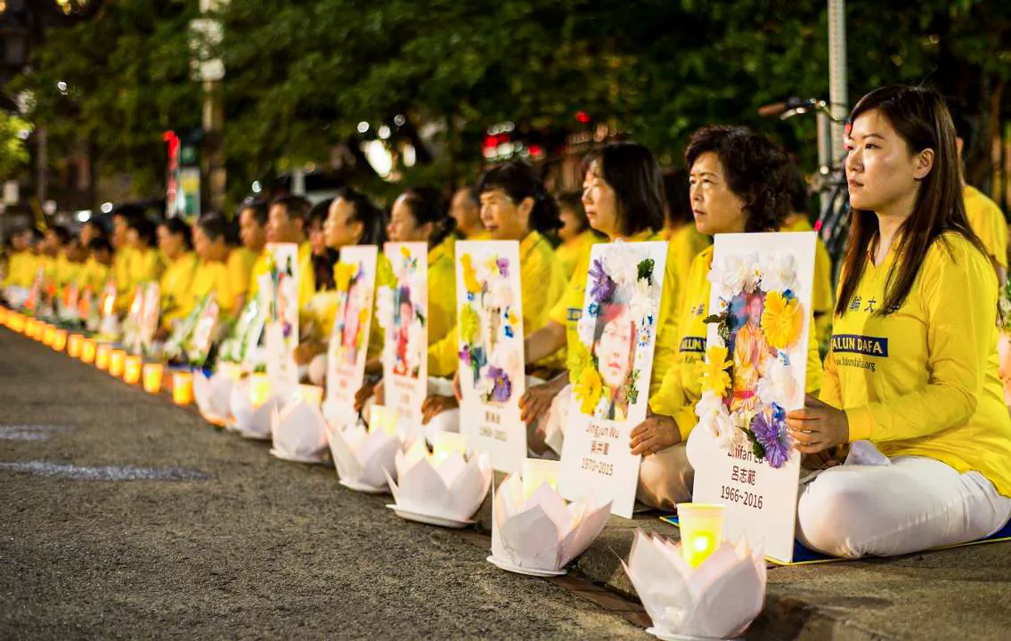 Falun Gong practitioners participate in a candlelight vigil, holding photos of fellow adherents who had died as a result of persecution in China, in front of the Chinese Consulate in Toronto on July 13, 2019. (Handout)
