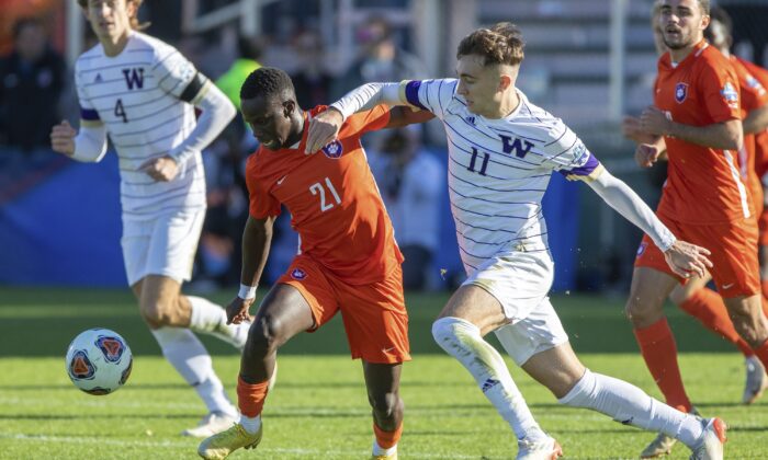 Clemson's Ousmane Sylla (21) and Washington's Nick Scardina (11) battle for a ball during the NCAA game in Cary, N.C., on Dec. 12, 2021. (Ben McKeown/AP Photo)