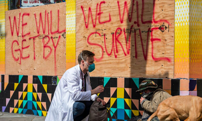 Stuart Malcolm, a doctor with the Haight Ashbury Free Clinic, speaks with homeless people about the coronavirus (COVID-19) in the Haight Ashbury area of San Francisco, Calif. on Mar. 17, 2020. (JOSH EDELSON/AFP via Getty Images)