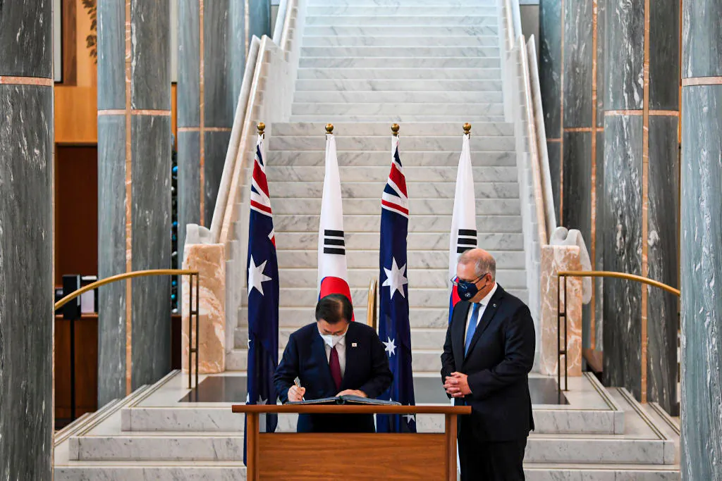 Australian Prime Minister Scott Morrison (R) looks on as South Korean President Moon Jae-in signs the official visitors book at Parliament House on December 13, 2021 in Canberra, Australia.   (Lukas Coch - Pool/Getty Images)