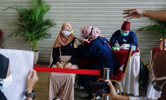 A girl receives a dose of China's Sinovac Biotech vaccine against the coronavirus disease (COVID-19) at Ancol amusement park in Jakarta, Indonesia, on July 24, 2021. (Willy Kurniawan/Reuters)