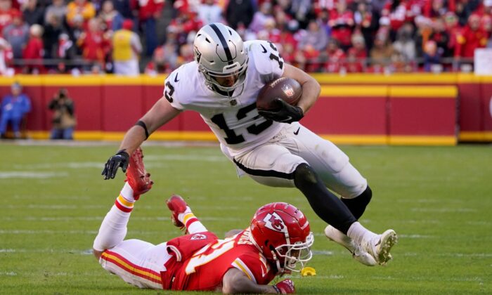Las Vegas Raiders wide receiver Hunter Renfrow (13) is stopped by Kansas City Chiefs cornerback Mike Hughes (21) defends during the second half of an NFL football game in Kansas City, Mo., on Dec. 12, 2021. (Ed Zurga/AP Photo)