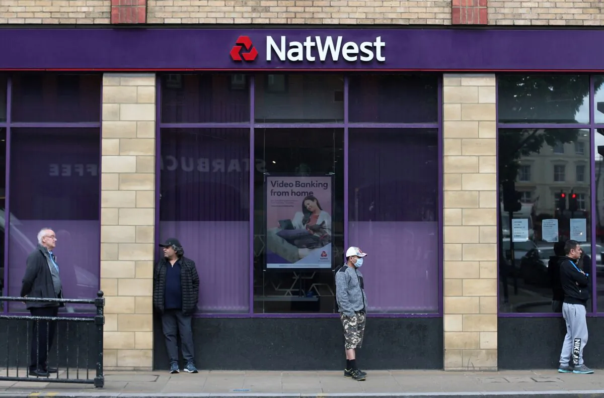 People maintain social distance while they queue outside a Natwest bank in Wimbledon, following the outbreak of the coronavirus disease (COVID-19), London, Britain, on May 1, 2020. (Hannah McKay/Reuters)