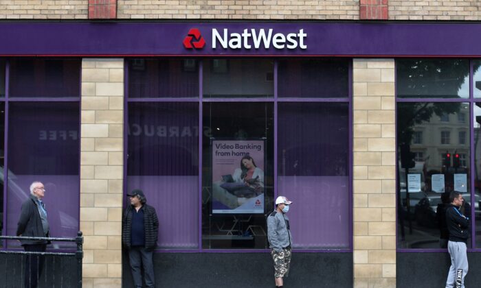 People maintain social distance while they queue outside a Natwest bank in Wimbledon, following the outbreak of the coronavirus disease (COVID-19), London, Britain, on May 1, 2020. (Hannah McKay/Reuters)