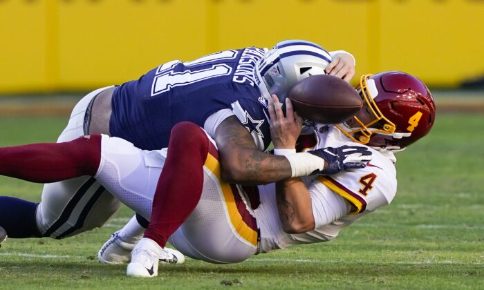 Washington Football Team quarterback Taylor Heinicke (4) fumbles the ball as he is sacked by Dallas Cowboys outside linebacker Micah Parsons (11) during an NFL game in Landover, Md., on Dec. 12, 2021. (Alex Brandon/AP Photo)