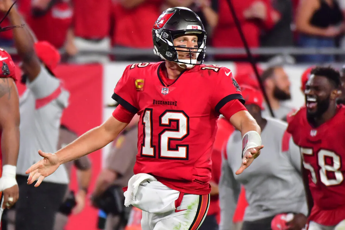 Tom Brady #12 of the Tampa Bay Buccaneers celebrates a 58-yard game-winning touchdown pass to Breshad Perriman #16 (not pictured) in overtime against the Buffalo Bills at Raymond James Stadium in Tampa, Fla., on Dec. 12, 2021. (Photo by Julio Aguilar/Getty Images)