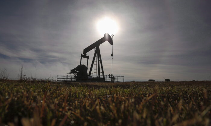 A pumpjack works at a wellhead on an oil and gas installation near Cremona, Alta., in a file photo. (The Canadian Press/Jeff McIntosh)