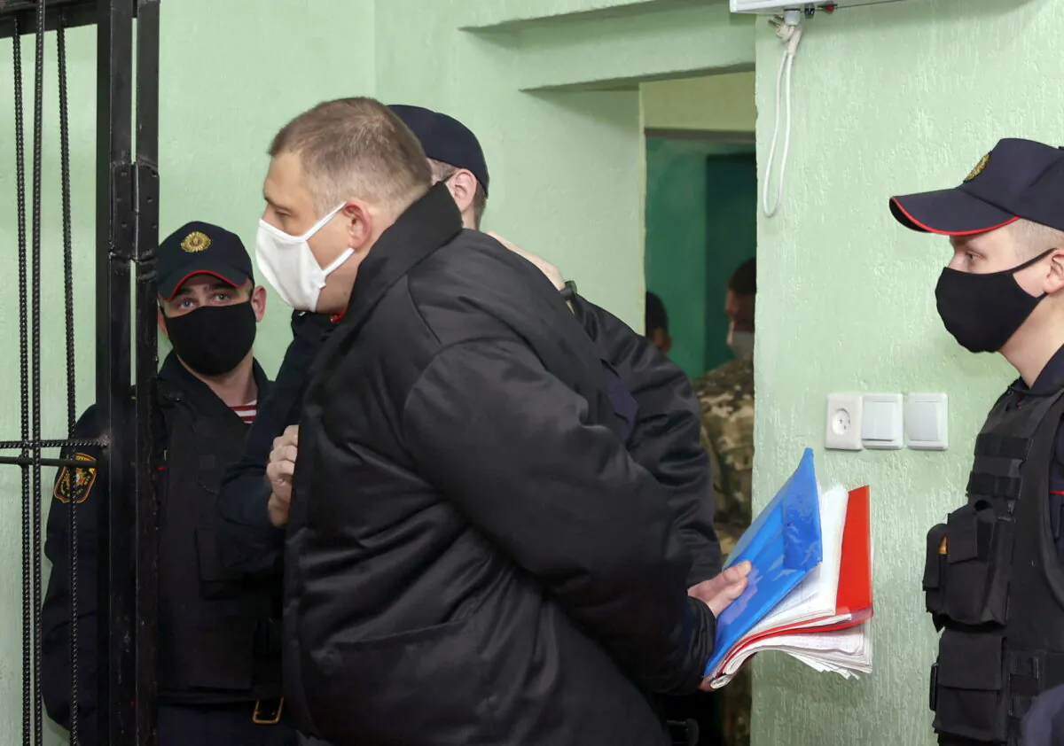 Syarhei Tsikhanouski is escorted before a court hearing in Gomel (Homel), Belarus, on Dec. 14, 2021. (Sergei Kholodilin/BelTA/Handout via Reuters)