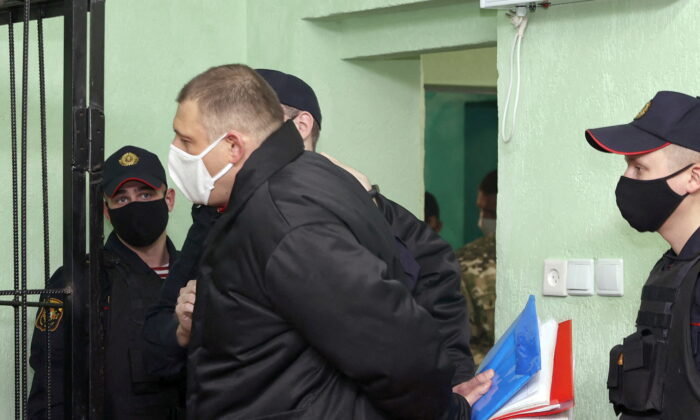 Syarhei Tsikhanouski is escorted before a court hearing in Gomel (Homel), Belarus, on Dec. 14, 2021. (Sergei Kholodilin/BelTA/Handout via Reuters)