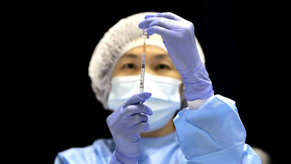 A health care worker fills a syringe with the Pfizer vaccine on the opening day of a COVID-19 mass vaccination clinic at the Perth Convention and Exhibition Centre in Perth, Australia on Aug. 16, 2021. (AAP Image/Richard Wainwright)