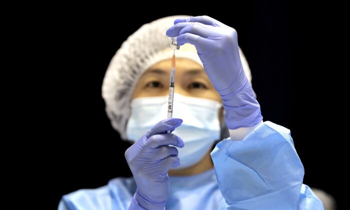 A health care worker fills a syringe with the Pfizer vaccine on the opening day of a COVID-19 mass vaccination clinic at the Perth Convention and Exhibition Centre in Perth, Australia on Aug. 16, 2021. (AAP Image/Richard Wainwright)