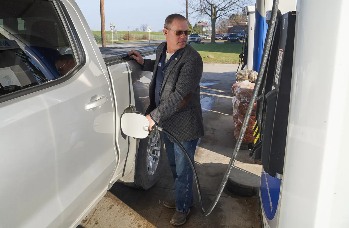 Greg Alexander fills his pickup truck with gas in Croswell, Michigan, on December 10, 2021. (Steven Kovac/The Epoch Times)