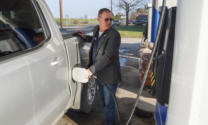 Greg Alexander fills his pickup truck with gas in Croswell, Michigan, on December 10, 2021. (Steven Kovac/The Epoch Times)