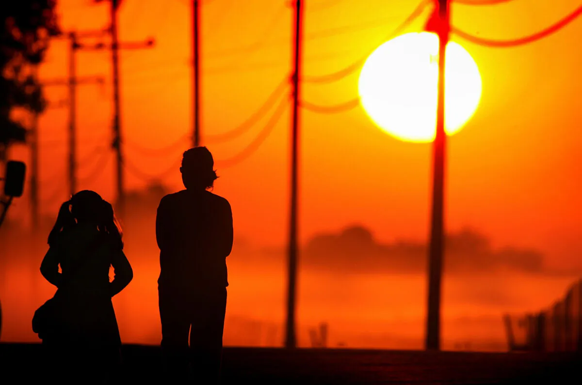 In this file photo, a girl walks to her school bus stop at sunrise with another person near Stockton, Calif. (David McNew/Getty Images)