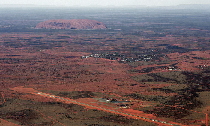 The resort town of Yulara (C) and Connellan Airport (front) lie before the arkose massif of Uluru (Ayers Rock) rising 348 metres above the surrounding desert of central Australia, 17 February 2007(TORSTEN BLACKWOOD/AFP via Getty Images)