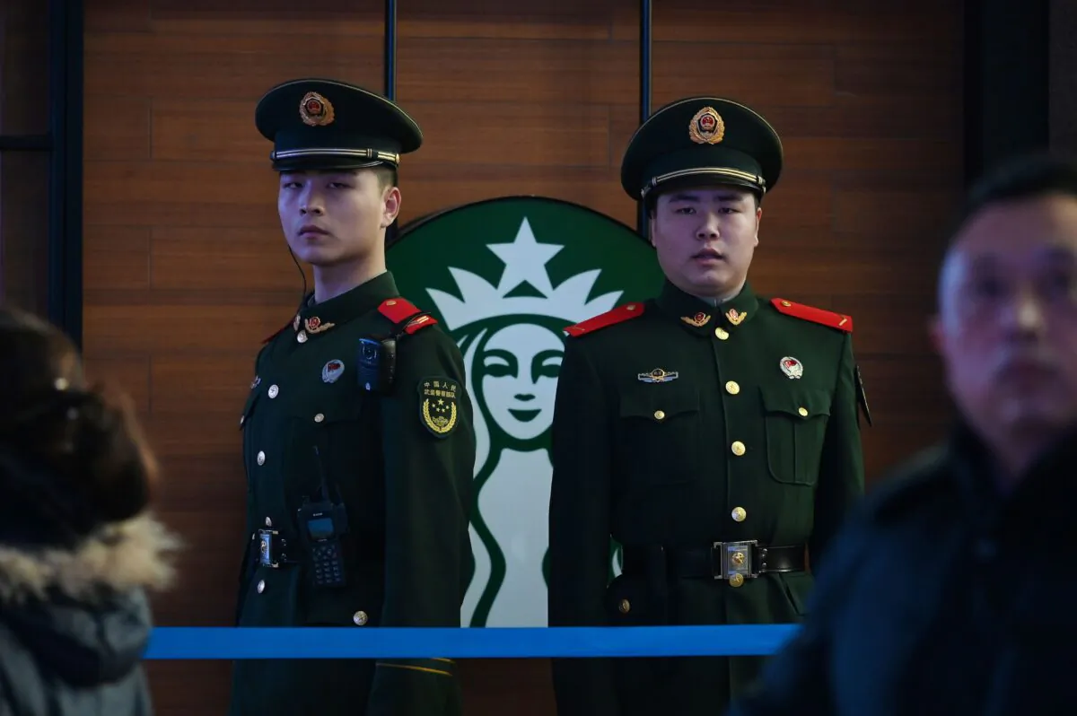 Paramilitary police officers stand guard near a Starbucks coffee in Beijing Railway Station in Beijing on Feb. 2, 2019. (Greg Baker/AFP via Getty Images)