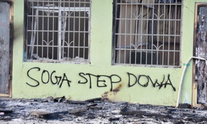 Anti-government messages adorn a burnt-out building in Honiara, Solomon Islands, on Nov. 27, 2021, (Charley Piringi/AFP via Getty Images)