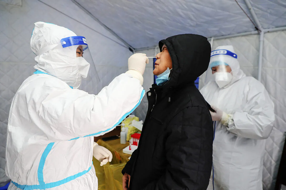 A resident undergoes a nucleic acid test for COVID-19 in Manzhouli in the northern Inner Mongolia region, China, on Nov. 29, 2021. (STR/CNS/AFP via Getty Images)