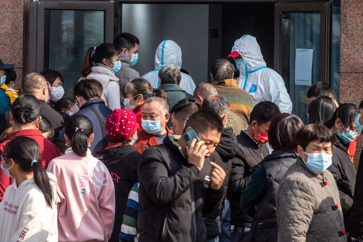 People wait to undergo nucleic acid tests for the Covid-19 coronavirus during a mass testing in Ningbo, in eastern China's Zhejiang province on Dec. 7, 2021. (STR/AFP via Getty Images)