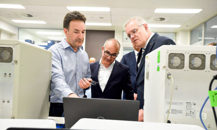 Australian Prime Minister Scott Morrison (R) and Victorian Deputy Premier James Merlino (C) tour The Peter Doherty Institute for Infection and Immunity in Melbourne, Australia, with Dr Julian Druce, head of the Virus Identification Lab (M) on Dec. 14, 2021 (Andrew Henshaw/POOL/AFP via Getty Images)