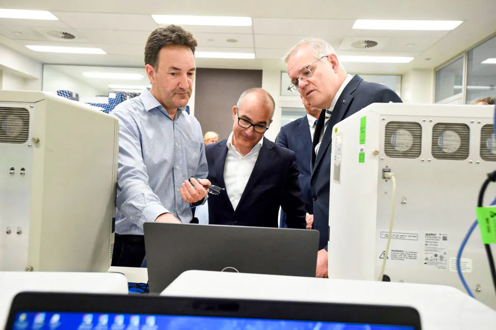 Australian Prime Minister Scott Morrison (R) and Victorian Deputy Premier James Merlino (C) tour The Peter Doherty Institute for Infection and Immunity in Melbourne, Australia, with Dr Julian Druce, head of the Virus Identification Lab (M) on Dec. 14, 2021 (Andrew Henshaw/POOL/AFP via Getty Images)