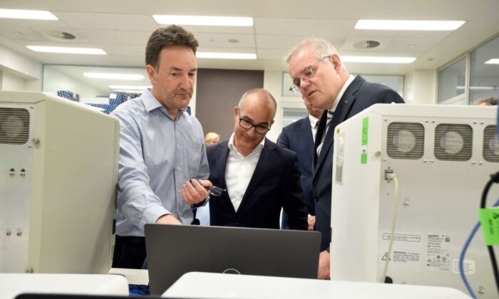 Australian Prime Minister Scott Morrison (R) and Victorian Deputy Premier James Merlino (C) tour  Peter Doherty Institute for Infection and Immunity in Melbourne, Australia, with Dr Julian Druce, head of the Virus Identification Lab (M) on Dec. 14, 2021 (Andrew Henshaw/POOL/AFP via Getty Images)