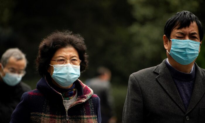 People wearing protective masks following the COVID-19 outbreak walk on a street in Shanghai, China, on Dec. 14, 2021. (Aly Song/Reuters)
