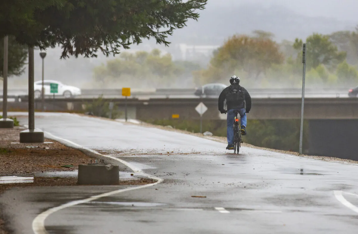 A man rides a bicycle along  the San Diego Creek in Irvine, Calif., on Dec. 14, 2021. (John Fredricks/The Epoch Times)