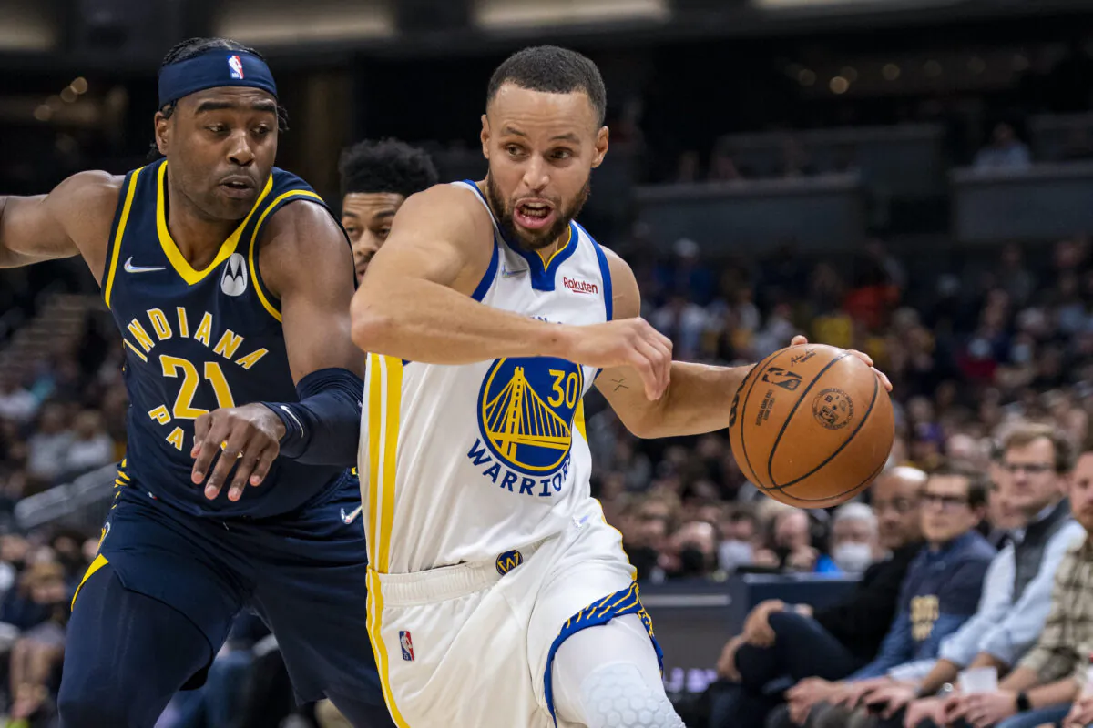 Golden State Warriors guard Stephen Curry (30) drives the ball past the defense of Indiana Pacers guard Kelan Martin (21) during the first half of an NBA basketball game in Indianapolis, on Dec. 13, 2021. (Doug McSchooler/AP Photo)