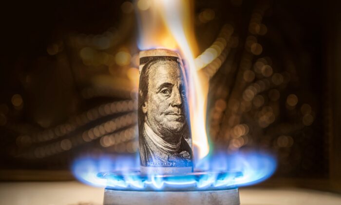 The american dollar is burning in the fire. Burning gas burner on the background of one hundred dollars. The concept the rise in the price of gas in USA. Expensive gas supply