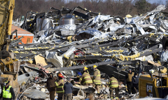 Emergency workers search through what is left of the Mayfield Consumer Producers candle factory, in Mayfield, Ky., on Dec. 11, 2021. (John Amis/AFP via Getty Images)