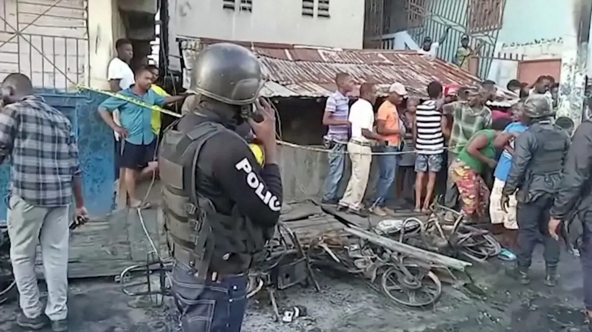 People stand at the site of an explosion in Cap-Haitien, Haiti, on Dec. 14, 2021, in this still image obtained from Reuters TV footage. (Reuters TV/via Reuters)