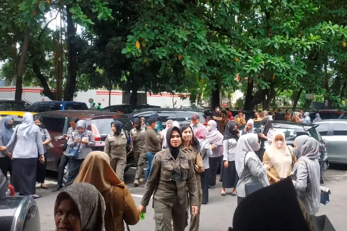 People wait outside after evacuating a government building following an earthquake in Makassar, South Sulawesi, Indonesia, on Dec. 14, 2021. (Daeng Mansur/AP Photo)