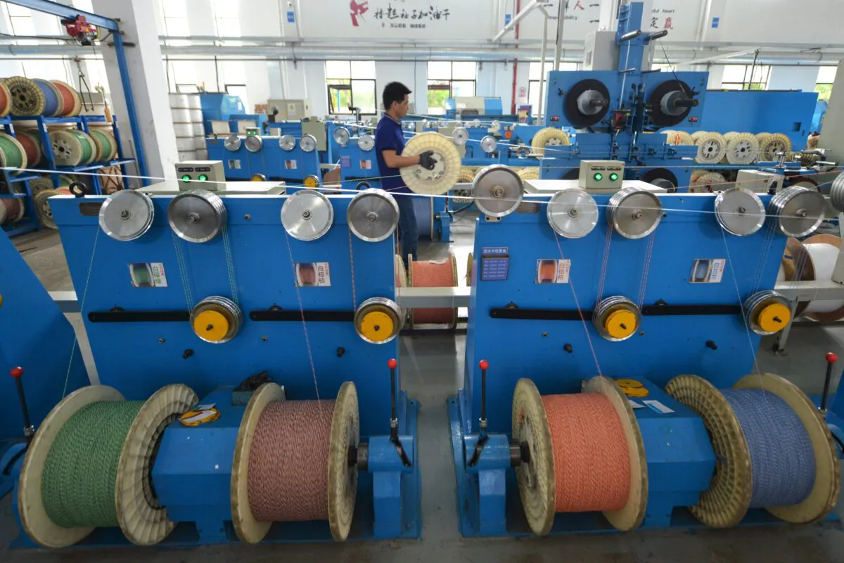 An employee works at a production line manufacturing optical fiber cables at a factory in Huzhou, Zhejiang Province, China, on May 15, 2019. (Stringer/Reuters)