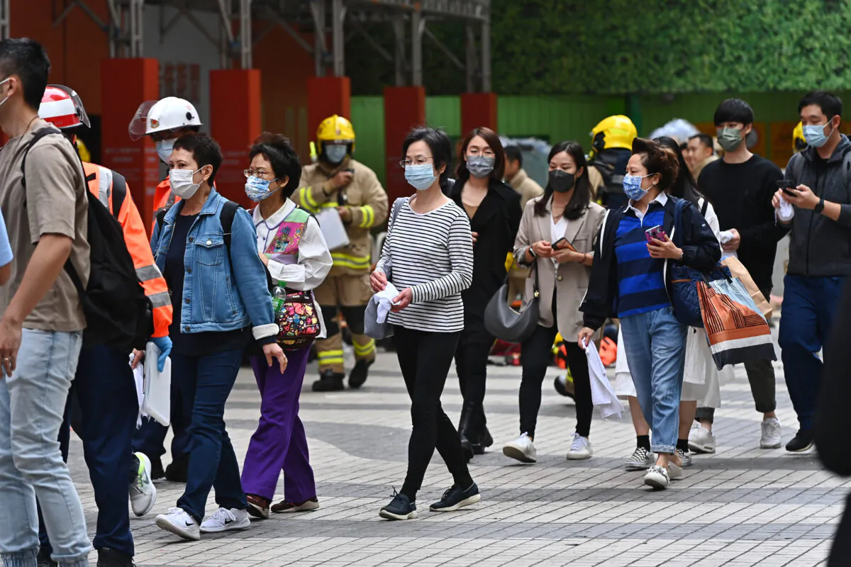 People walk out from the World Trade Centre in Hong Kong, on Dec. 15, 2021. (Sung Pi-lung/The Epoch Times)