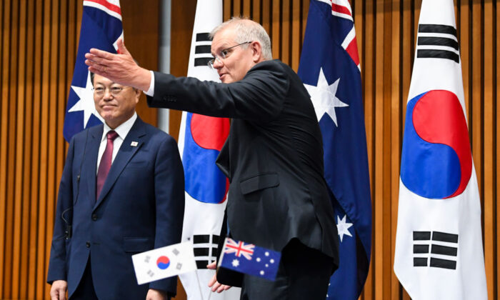 (L-R) South Korean President Moon Jae-in and Australian Prime Minister Scott Morrison witness a signing ceremony at Parliament House on December 13, 2021 in Canberra, Australia. (Lukas Coch - Pool/Getty Images)