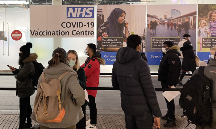 A queue of people waiting to receive their COVID-19 booster jab at an NHS vaccination centre in London on Dec. 14, 2021.(Leon Neal/Getty Images)